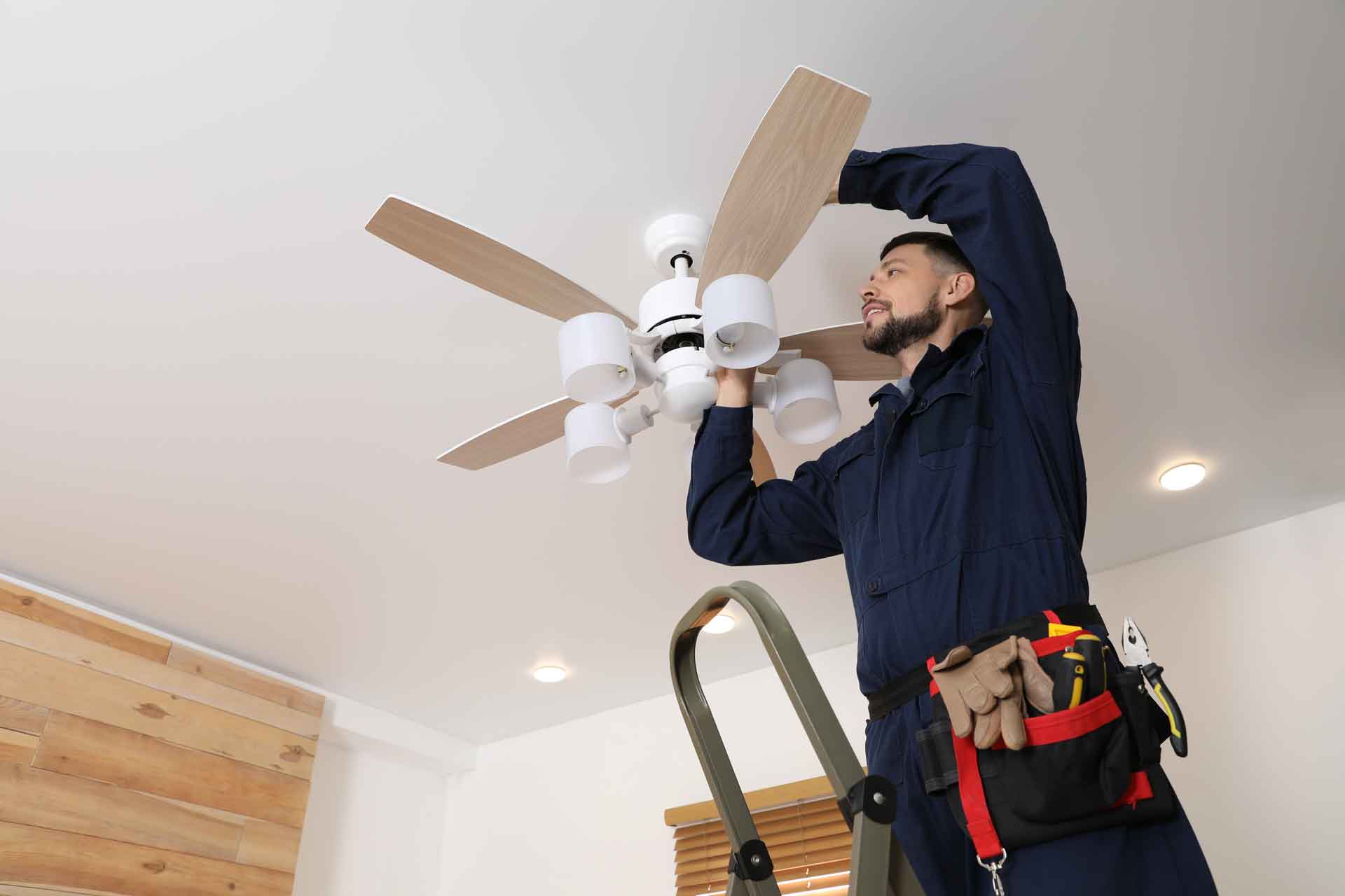 Electrician installing a ceiling fan