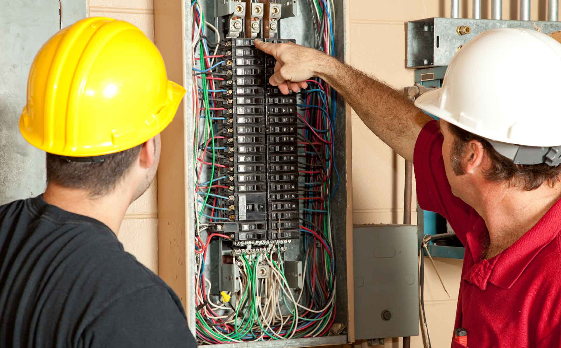 Two electricians working on a circuit breaker