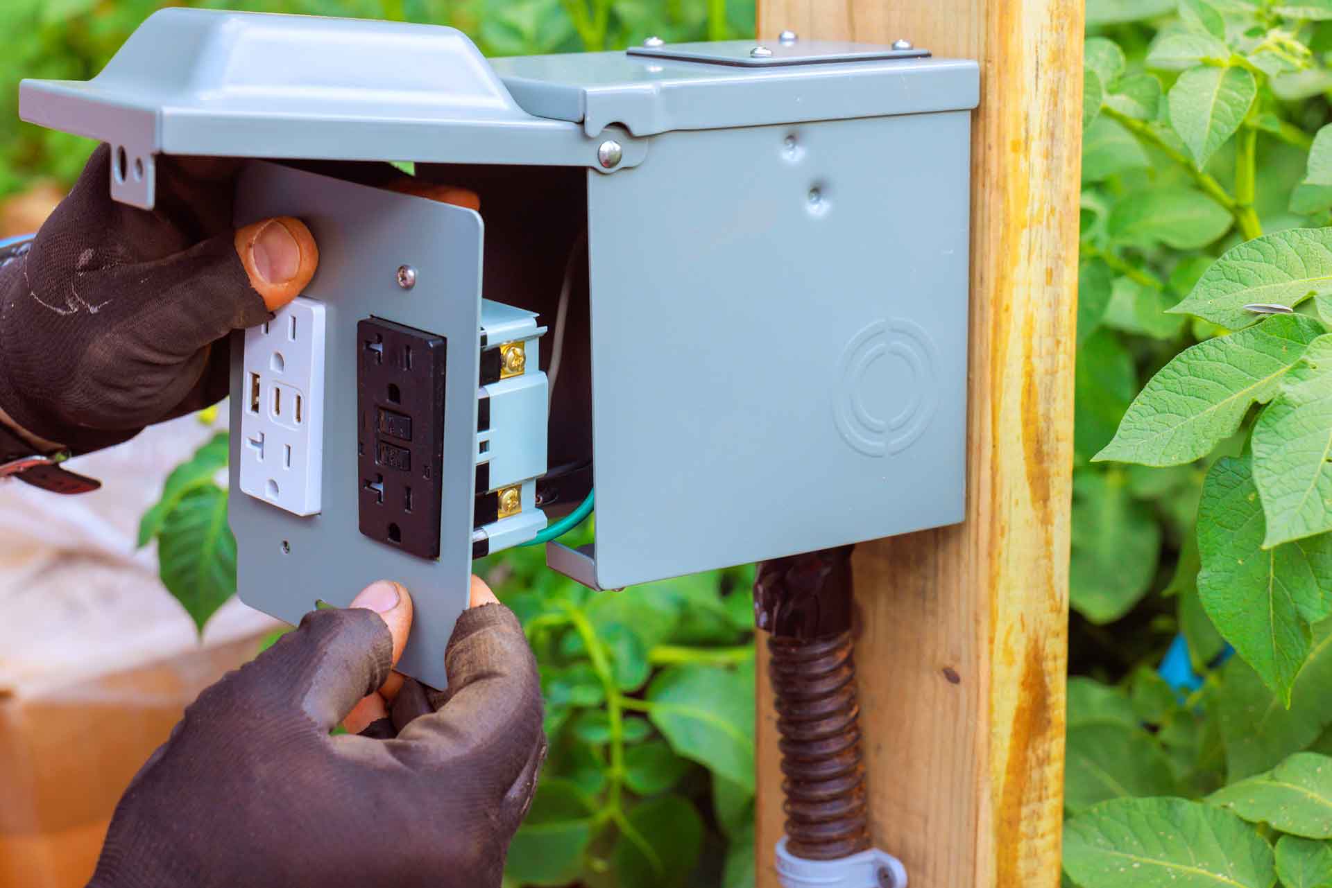 Electrician installing a GFCI outlet outdoors