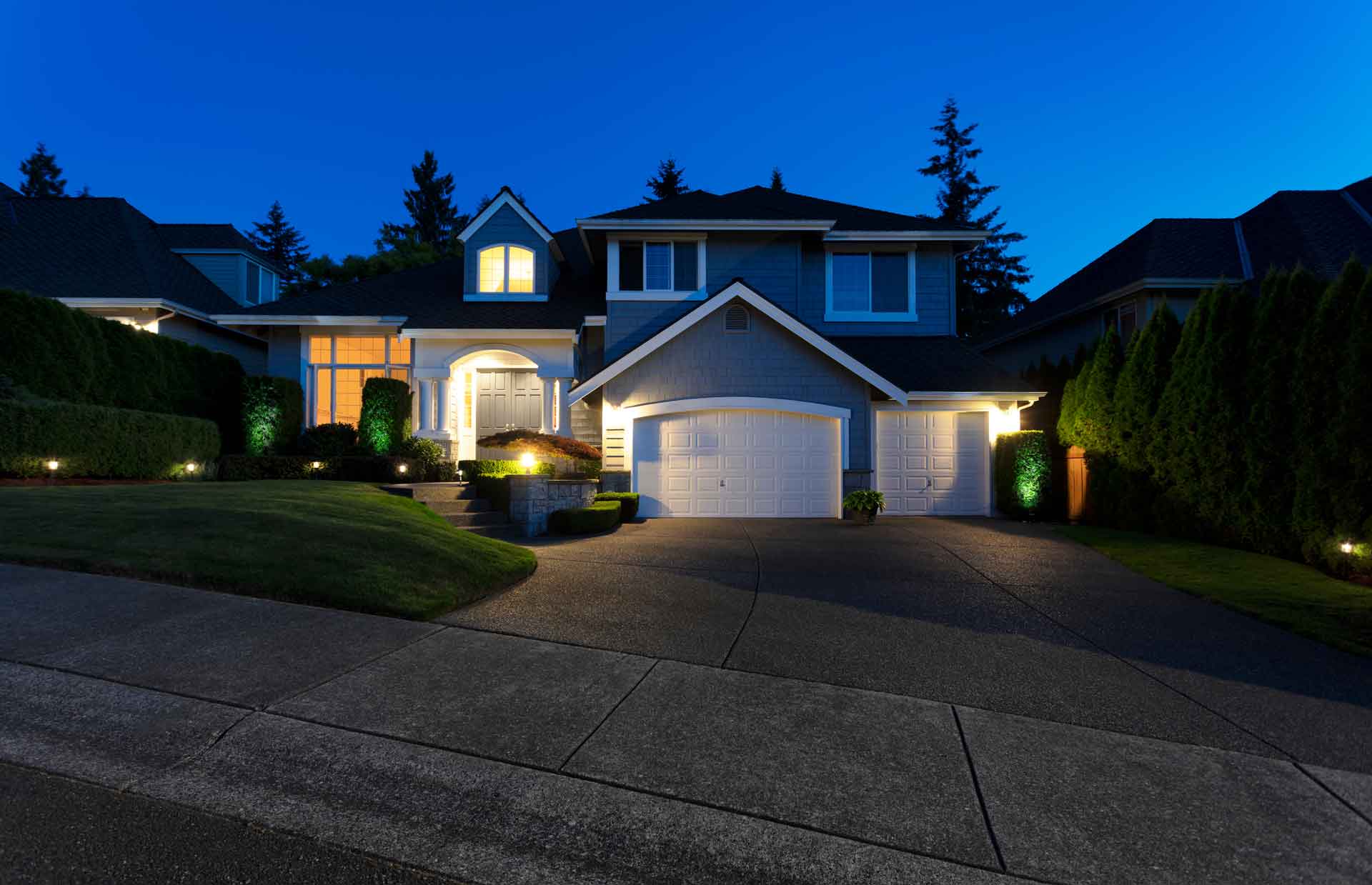Exterior shot of house at night with landscape lights